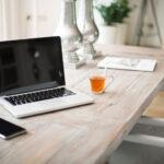 Macbook mit Smartphone auf Schreibtisch