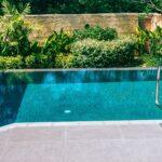 Pool mit Leiter, Fliesenrand und Vegetation | Sandfilteranlage